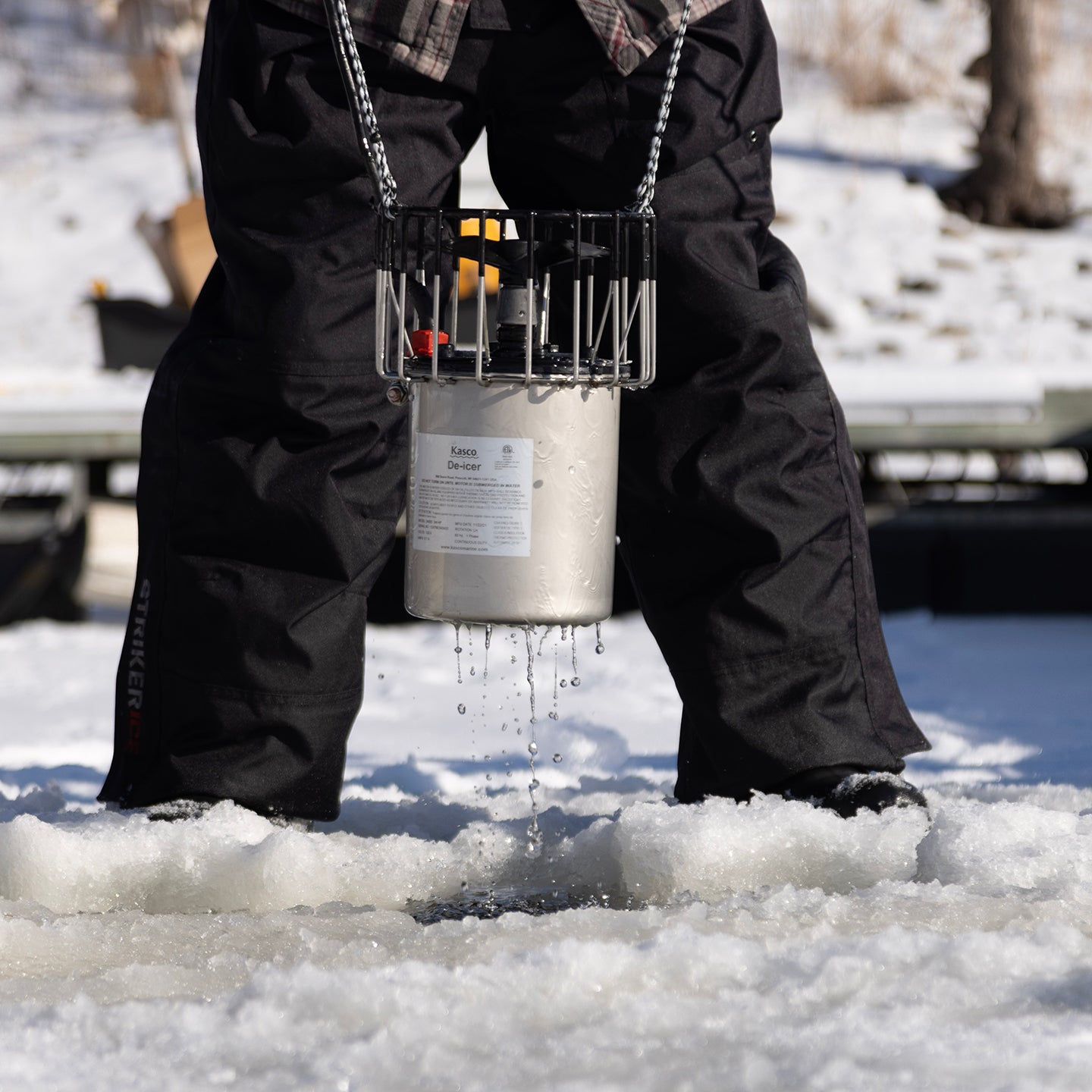Kasco de-icer being lowered through ice during winter installation
